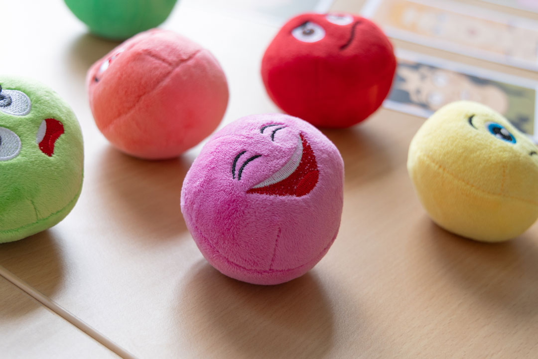 bunte, flauschige Stoffbälle mit verschiedenen Gesichtsausdrücken
